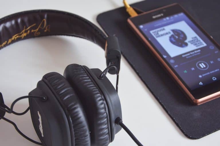 Słuchawki i smartphone z muzyką na Spotify.
