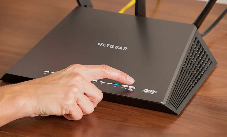 Ręka włącza router NETGEAR.