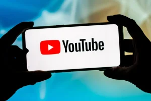 Smartfon z logo YouTube w rękach.