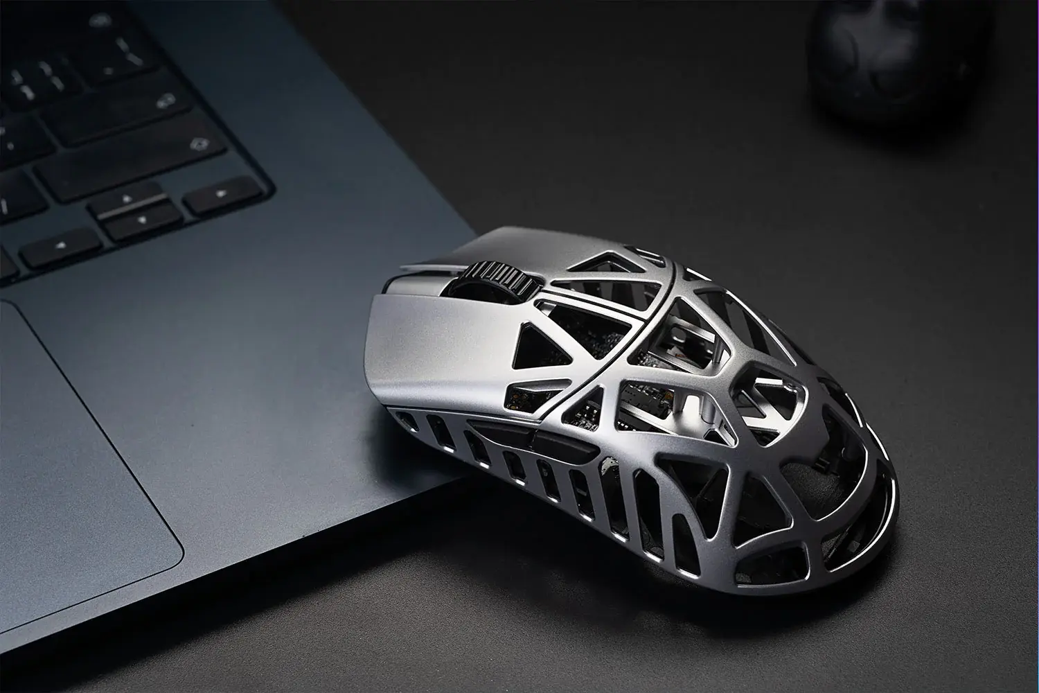 Nowoczesna mysz komputerowa obok laptopa.